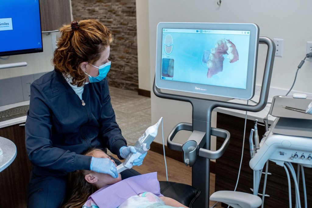 Dr. Baillargeon using an intraoral scanner to scan a patient's mouth.