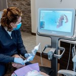 Dr. Baillargeon using an intraoral scanner to scan a patient's mouth.